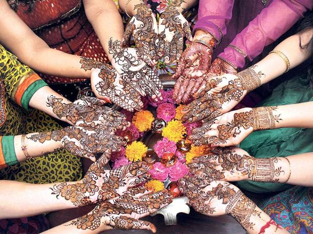 Women prepare mehendi designs on their hand for the Karva Chauth in Indore. (PTI photo)
