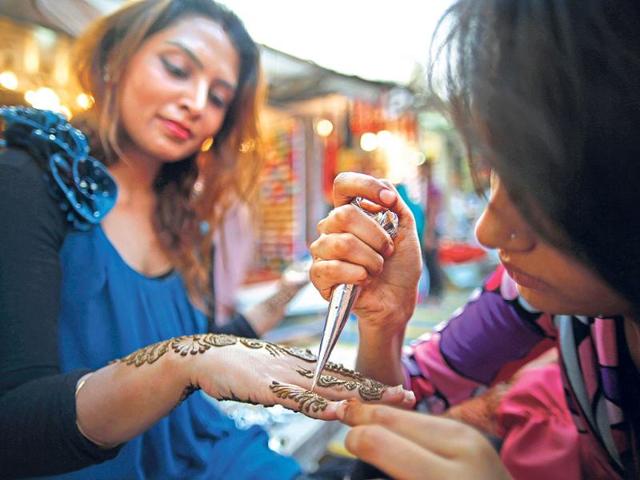 A woman gets her hand decorated with mehendi ahead of Karva Chauth in New Delhi. (AP photo)