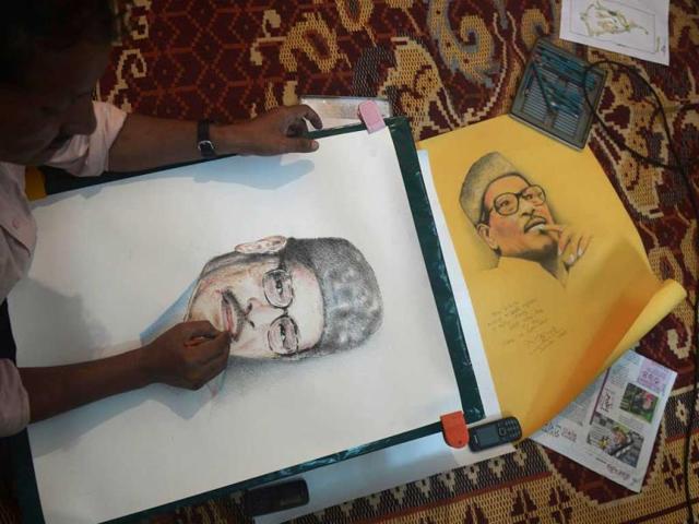 An artist draws a picture of late singer Manna Dey at his ancestral residence where he spent most of his life, in Kolkata on October 24, 2013. (AFP Photo)