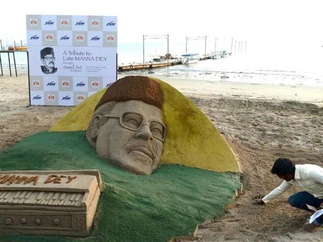 An Indian artist gives finishing touches to a sand sculpture of the late Bollywood playback singer Manna Dey on the beach in Mumbai on October 24, 2013. (AFP Photo)