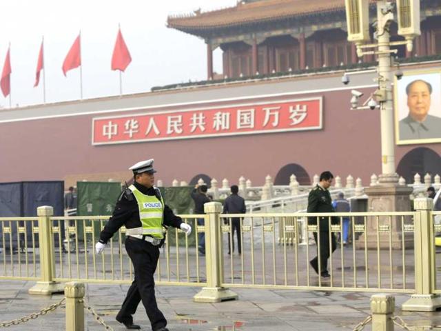 A-police--personnel--walks-past-the-portrait-of-the-late-Chinese-leader-Mao-Zedong-as-other-policemen-clean-up-after-a-car-accident-at-the-Tiananmen-Square-in-Beijing-Reuters-photo