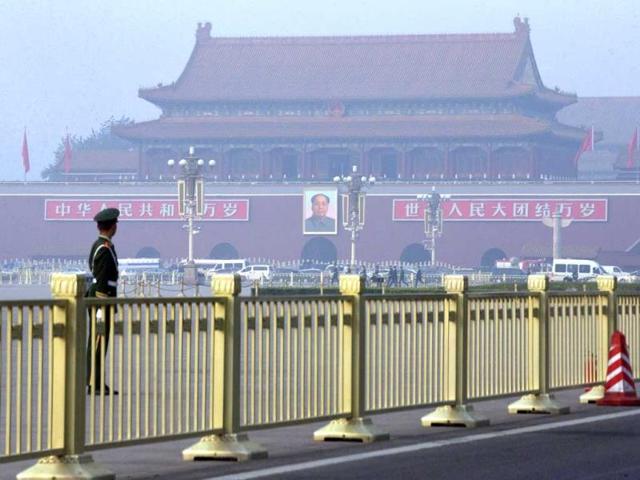 Paramilitary policemen guard and patrol Tiananmen Square, near Tiananmen Gate, back, where a vehicle veered into a crowd, in Beijing (AP Photo)