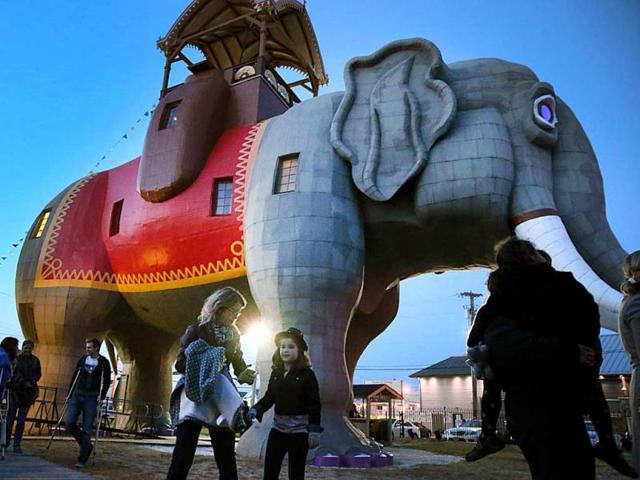 People gather to watch the lighting of Margate NJ, landmark Lucy the Elephant to commemorate the one year anniversary of Superstorm Sandy hitting the New Jersey Shore. (AP Photo)