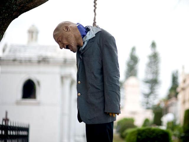 A dummy is hanged from a tree as a decoration for a touristic tour at the General Cemetary in San Salvador, El Salvador. Salvadorean celebrate Halloween and the eve of the All Saints' Day . AFP PHOTO
