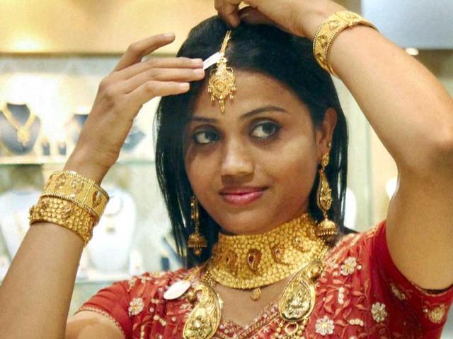 A woman with gold ornaments at a jewellery shop on the occasion of Dhanteras in Jamshedpur. (PTI Photo)
