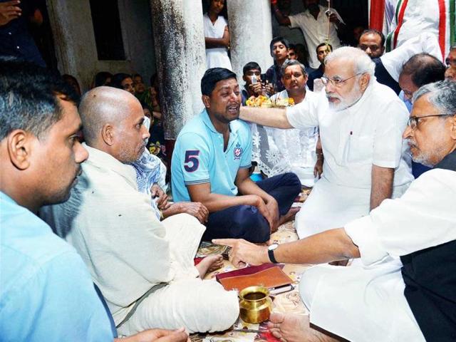 BJP's prime minister candidate Narendra Modi and senior party leader Sushil Kumar Modi console the family members of Rajnarain Singh, a victim of the recent serial bomb blasts, in Patna. PTI Photo