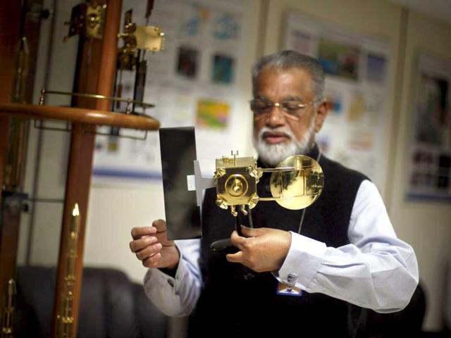Isro chairman K Radhakrishnan holds a model of Mars orbiter at his office in New Delhi. (AP photo)
