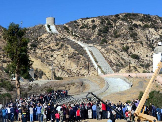 A crowd gathers to watch a re-enactment of the moment the Los Angeles Aqueduct gates were first opened 100 years ago in Sylmar, California, sending water gushing towards the city during an event marking the 100th anniversary of the opening of the 233-mile Los Angeles Aqueduct. (AFP Photo)