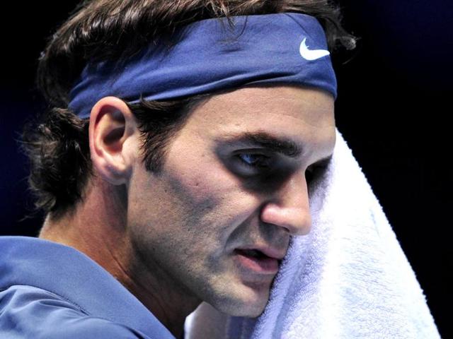 Switzerland's Roger Federer wipes his face between points against Serbia's Novak Djokovic during their ATP World Tour Finals tennis match at the O2 Arena in London. (AFP Photo)