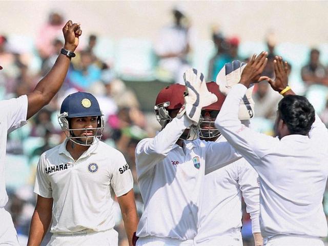 West Indies players celebrate the dismissal of Rohit Sharma (2nd L) during the third day of the first Test match at Eden Gardens in Kolkata. (PTI Photo)