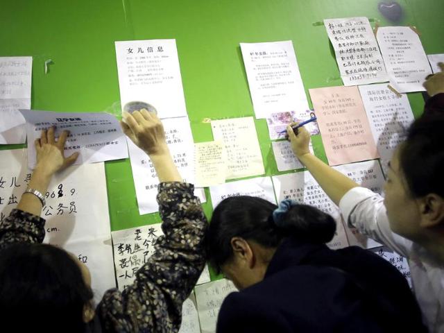 Women put up the information cards of their bachelor family members on the wall during a mass match-making event ahead of Singles Day in Shanghai, China. (AP Photo)