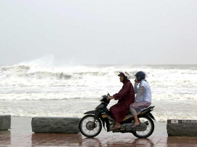 People ride on a motorbike next to the beach in Danang city, Vietnam on Sunday.(AP PHOTO)