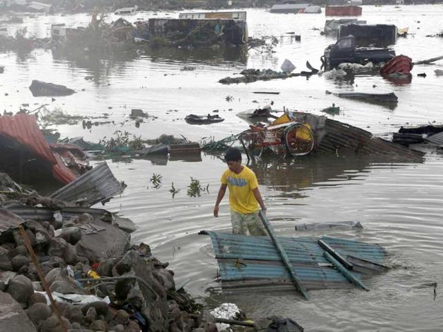 A man retrieves a house roofing from a river after super typhoon Haiyan battered Tacloban city in central Philippines on Sunday. (REUTERS PHOTO)