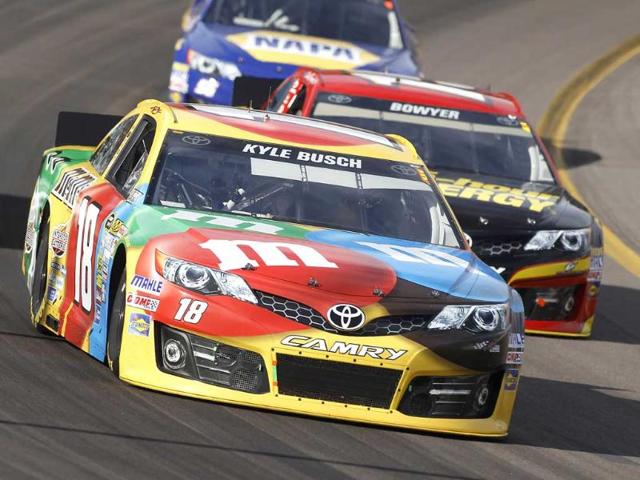 Driver Kyle Busch races out of turn two in front of Clint Bowyer during the AdvoCare 500 Nascar Sprint Cup Series auto race at Phoenix International Raceway in Avondale. (AP photo)