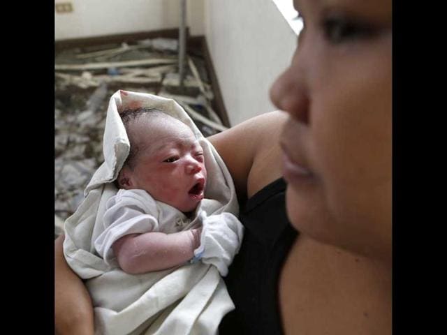 A woman holds newly born baby Beatriz at a makeshift birthing clinic in Tacloban city in Philippines. (Reuters photo)