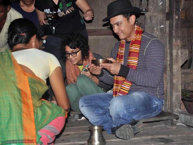 Aamir Khan enjoying a local drink, known as apong, sitting on a bamboo house-on-stilts in a village in Assam.
