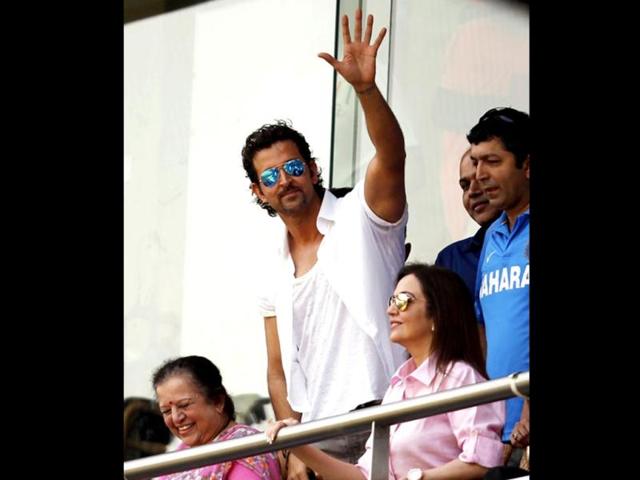 Hrithik Roshan waves to the crowd at Wankhede Stadium as he watches India battle West Indies during the last Test of Sachin Tendulkar. Nita Ambani, Kiran Rao, Ashutosh Gowarikar and Kunal Kohli also cheer on the legendary cricketer.