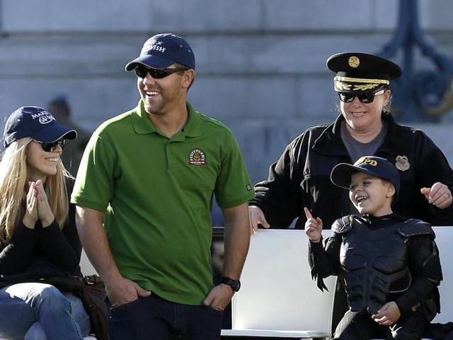 Miles Scott, dressed as Batkid, with his parents Natalie and Nick at a ceremony. Miles was diagnosed with luekaemia when he was 18-month-old. His cancer is in remission now.