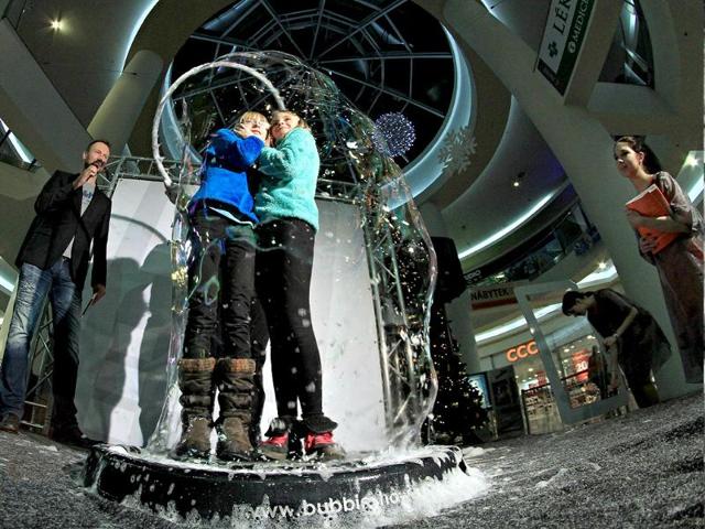 People speak on the telephone from inside a giant bubble made by professional bubblemaker Matej Kodes (R) during the Guinness Book of records attempt to set a new record in Olomouc, Czech Republic. (AFP photo)