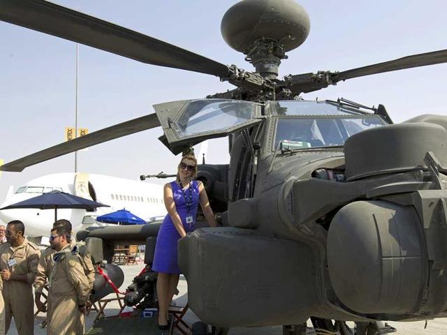 A visitor poses for a picture on a military helicopter during the Dubai Airshow. (Reuters Photo)