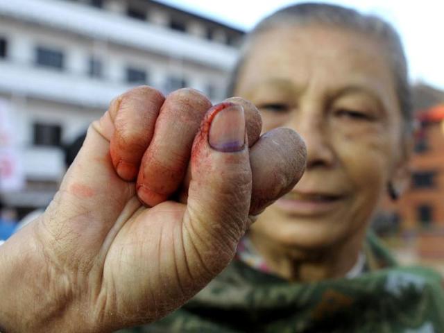 A Nepalese elder woman shows her finger after election official mark her finger with indelible ink at a polling station in Kathmandu. (AFP Photo)