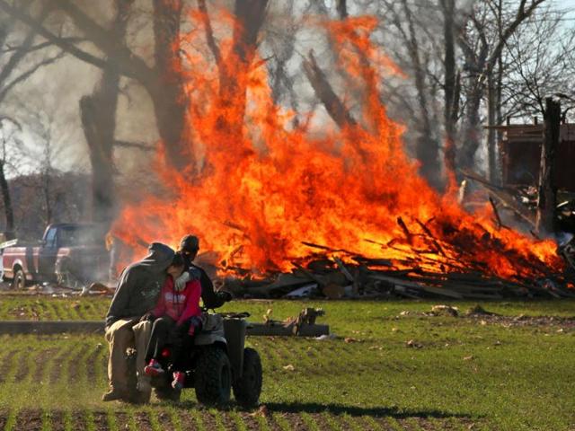 Residents of New Minden in Illinois, burn storm debris from a home destroyed in Sunday's tornado. (AP Photo)