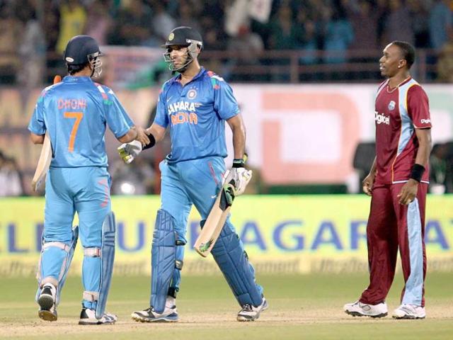 Yuvraj Singh and MS Dhoni celebrate the win over West Indies by 6 wickets during their 1st ODI in Kochi. (PTI photo)