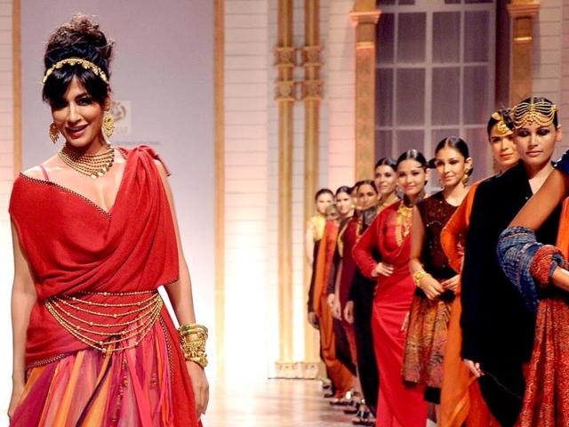 Check out her jewellery - the seven layered 'kamarbandh', the seven row necklace (haar). Chunky bangles and gold tiara-styled hair-band worn with a beehive style hairdo completes the look.