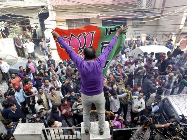 A-man-unfurls-the-BJP-s-flag-as-supporters-celebrate-the-party-s-victory-in-the-Delhi-assembly-elections-AP
