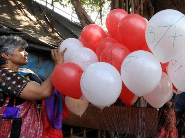 LGBT activists burst balloons during protest against the Supreme Court verdict which validated the section 377 of IPC, in Mumbai. (PTI PHOTO)