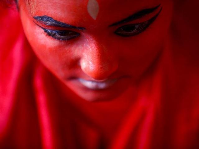 A woman paints her face red. (Reuters Photo)