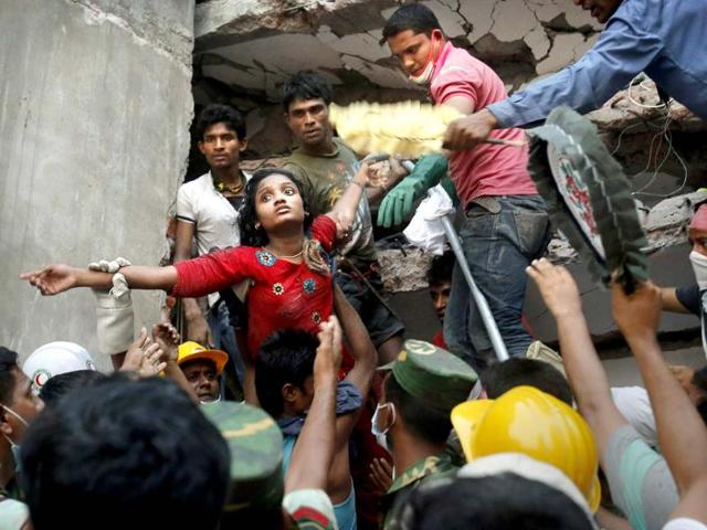 A Bangladeshi woman survivor is rescued at the site of Rana Plaza in Dhaka, Bangladesh that collapsed in April killing 1,129 people. (AP)