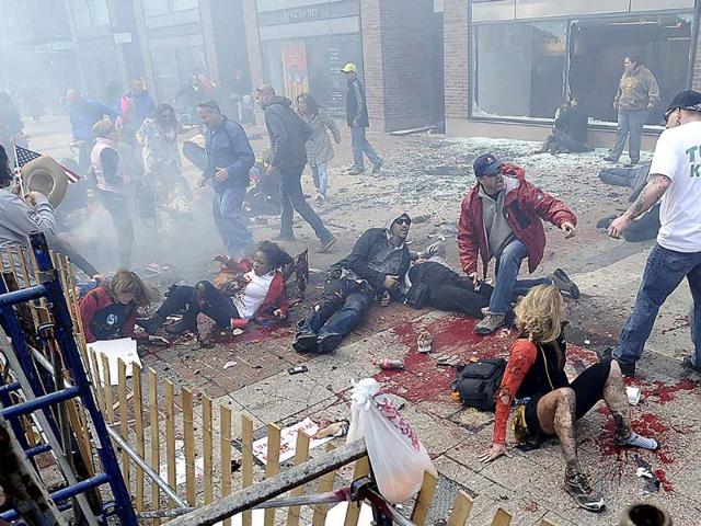 Injured people and debris lie on the sidewalk near the Boston Marathon finish line following an explosion in April. (AP)