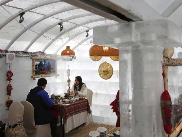A couple eat hot food at the Ice Palace in Shangri-La Hotel in the northern city of Harbin, Heilongjiang province. The Ice Palace, which is built by ice bricks, is open annually from December to February and attracts visitors during the Harbin Ice and Snow Festival. (Reuters photo)