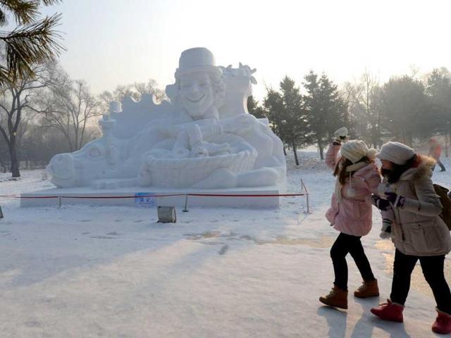 Visitors walk past a snow sculpture on display at the 15th Harbin International Ice and Snow Festival in Harbin, northeast China's Heilongjiang province. China's most famous and popular winter attraction has drawn a combined 28.5 million visitors in the past two years. (AFP photo)