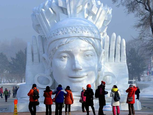 Visitors look at a snow sculpture on display at the 15th Harbin International Ice and Snow Festival in Harbin, northeast China's Heilongjiang province. (AFP photo)