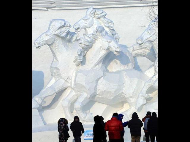 Visitors look at a snow sculpture on display at the Sun Island International Snow Sculpture Art Expo, as part of the 15th Harbin International Ice and Snow Festival in Harbin, northeast China's Heilongjiang province. (AFP photo)