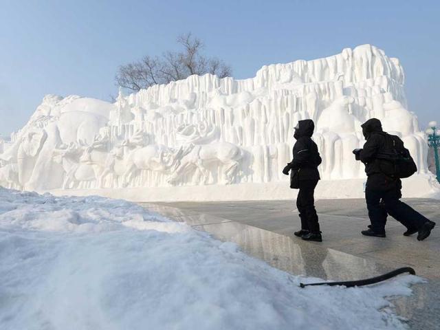 Visitors walk past a snow sculpture on display at the Sun Island International Snow Sculpture Art Expo, as part of the 15th Harbin International Ice and Snow Festival in Harbin, northeast China's Heilongjiang province. (AFP photo)