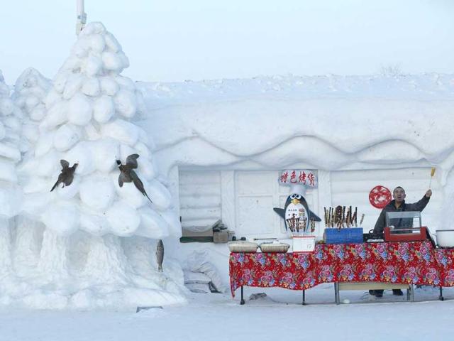 A vendor sells steamed corn at a stall with its exterior decorated with a snow sculpture at the Harbin International Snow Sculpture Art Expo in the northern city of Harbin, Heilongjiang. (Reuters photo)