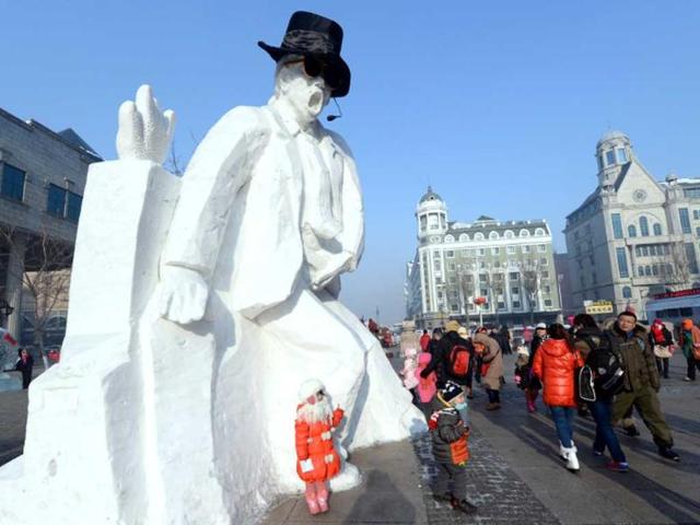 Visitors walk past an ice sculpture depicting the late pop star Michael Jackson on display along a street in conjunction with the China Ice and Snow World, of the 15th Harbin International Ice and Snow Festival in Harbin, northeast China's Heilongjiang province. (AFP photo)