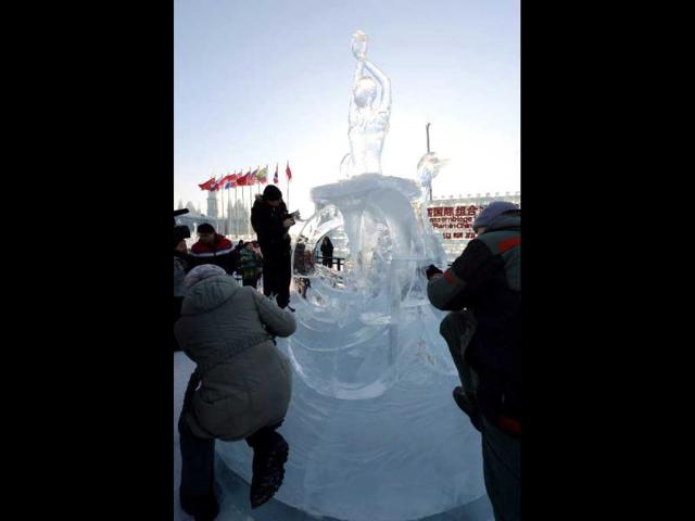A Russian ice sculpture team put the final touches to their creation, entitled 'Swan Lake' at the China Ice and Snow World, as workers make last minute preparations for the opening ceremony of the 15th Harbin International Ice and Snow Festival in Harbin, northeast China's Heilongjiang province. (AFP photo)