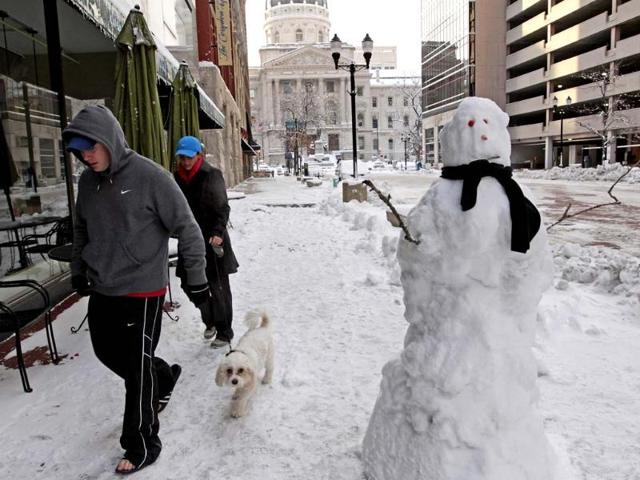 A couple walks their dog past a snowman near the State Capitol building in Indianapolis, Indiana. A blast of Arctic air gripped the vast middle of the United States, bringing the coldest temperatures felt in two decades, causing at least four deaths, forcing businesses and schools to close and canceling thousands of flights. (Reuters)