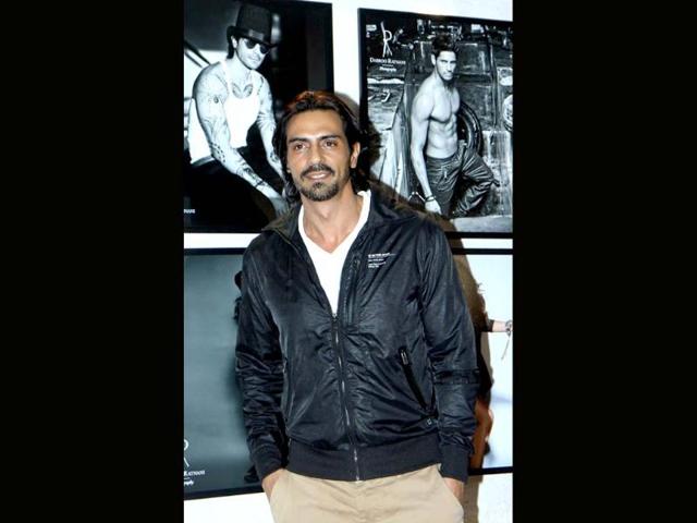 Actor Arjun Rampal poses in front of calendar shots featuring him and Siddharth Malhotra. Photographer Daboo Ratnani launched his calendar for 2014 featuring who's who of Bollywood on Sunday in Mumbai.