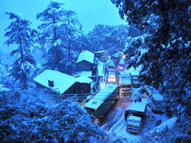 Vehicles move at snail's pace during heavy snow fall in Shimla. (Santosh Rawat/HT Photo)