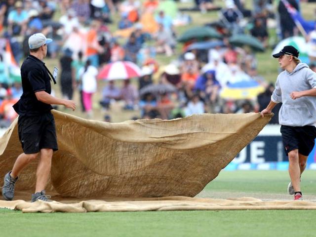 Ground staff protect the field with rain covers during the second ODI between New Zealand and India at Seddon Park in Hamilton. (AFP Photo)