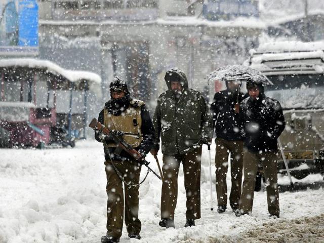 Policemen patrol a snow-covered street in Srinagar. Snowfall in Kashmir has disrupted power supply, air traffic and road traffic between Srinagar and Jammu. (AP Photo)