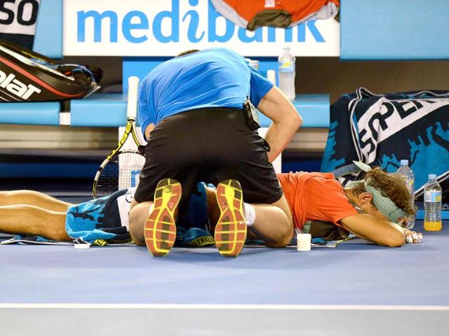 A trainer works on the back of Rafael Nadal of Spain between games against Stanislas Wawrinka of Switzerland in the men's singles final of the 2014 Australian Open in Melbourne. (AFP Photo) A trainer works on the back of Rafael Nadal of Spain between games against Stanislas Wawrinka of Switzerland in the men's singles final of the 2014 Australian Open in Melbourne. (AFP Photo)