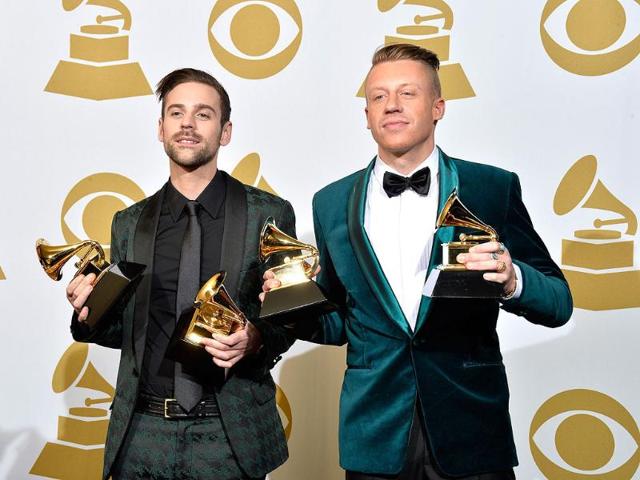 Recording artists Ryan Lewis (L) and Macklemore pose in the press room during the awards. They won four Grammy awards including best new artist.