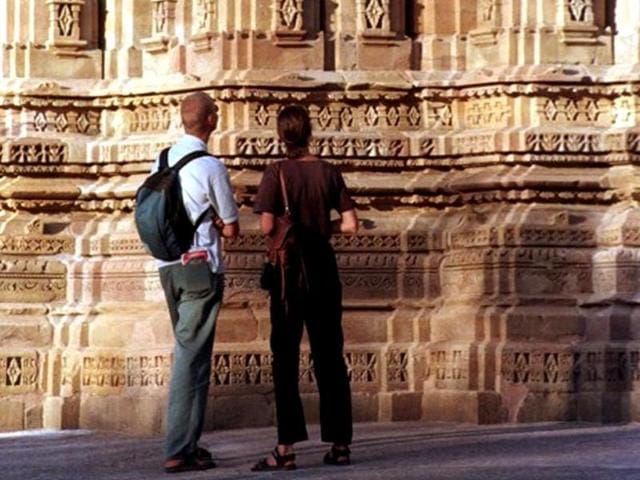 Two-foreign-tourists-take-a-look-at-sculptures-adorning-a-temple-at-the-Khajuraho-complex-built-in-the-tenth-century-under-the-Chandela-dynasty-AFP Two-foreign-tourists-take-a-look-at-sculptures-adorning-a-temple-at-the-Khajuraho-complex-built-in-the-tenth-century-under-the-Chandela-dynasty-AFP