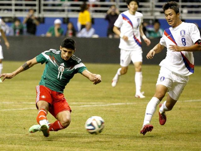 Mexico midfielder Alan Pulido scores a goal as Korea Republic midfielder Lee Ho defends during the second half in a friendly football match at Alamodome. (Reuters Photo)